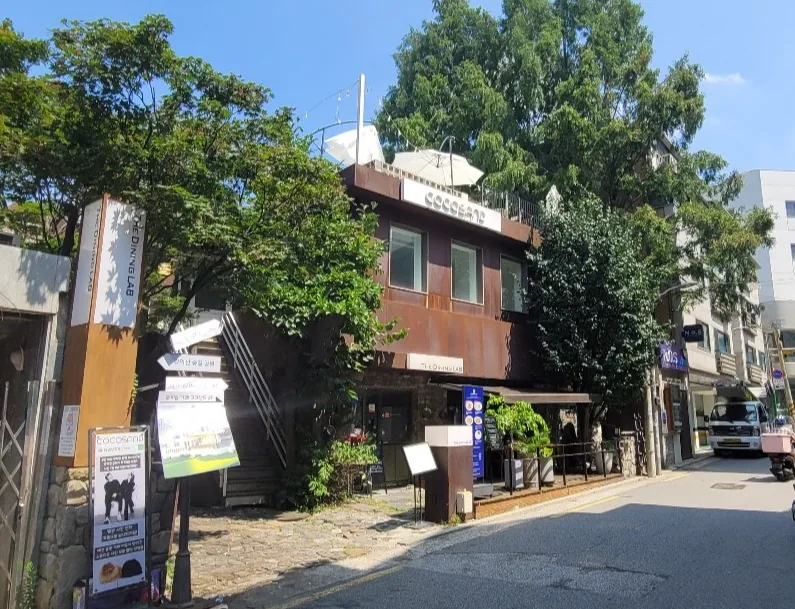 동교동 148-7 건물 전경 – 담쟁이에 덮인 2층 규모의 노후 건물과 1층 다이닝 점포