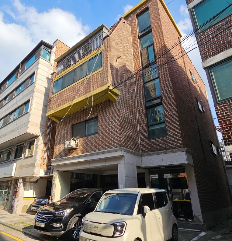 공릉동 351-13 외벽 – 붉은 벽돌 마감과 계단실이 드러난 건물 측면