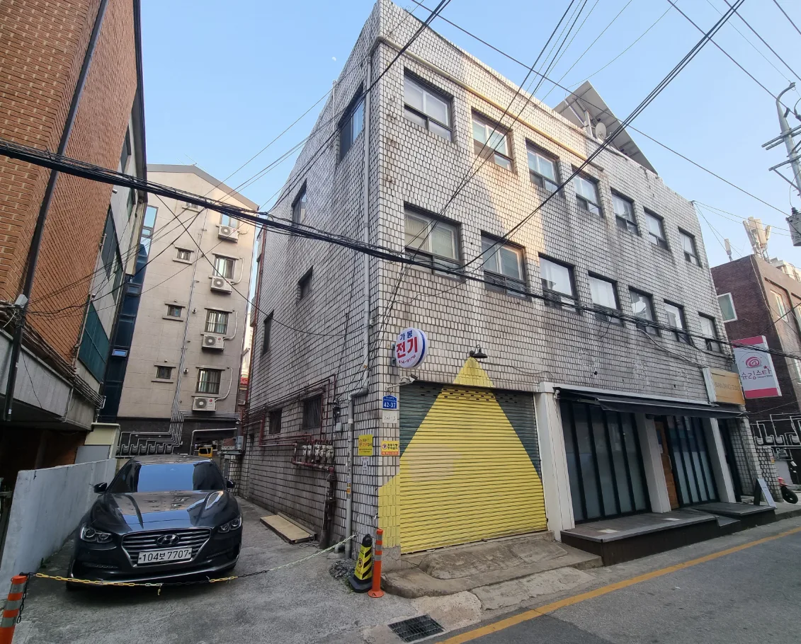 잠실동 206-3 측면 – 차량 진입이 가능한 옆 공간과 노란 셔터