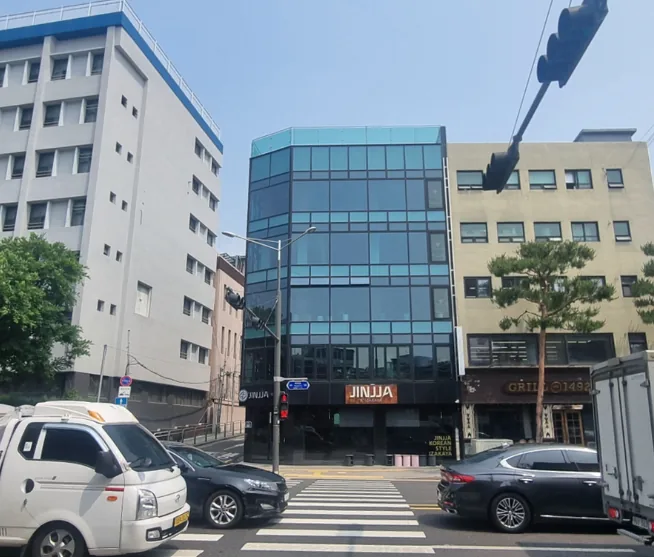 신당동 250-28 대로변 코너 전경 – 횡단보도 앞 유리 외관의 5층 건물