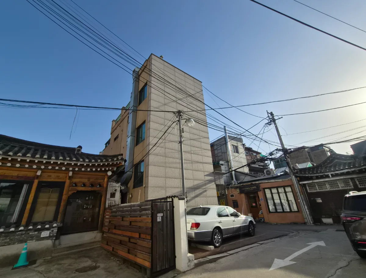 통의동 92 골목 – 한옥과 나란히 선 건물의 전면과 주차 공간